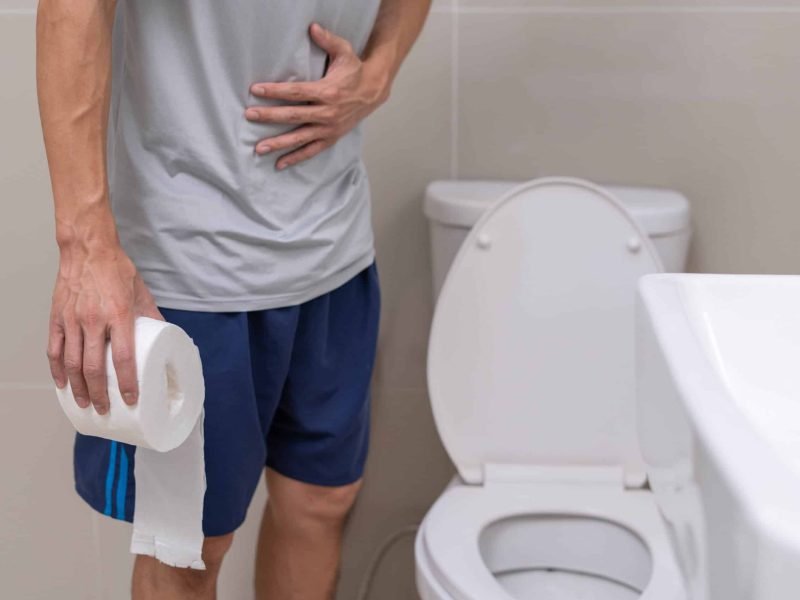Diarrhea , Abdominal pain, Constipation concept. Men have contraction and stomach pain. Man holding toilet paper in toilet.